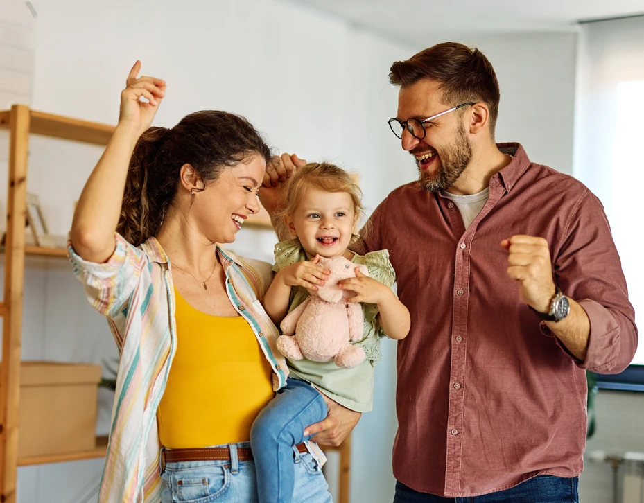 Scène intérieure montrant une main manipulant la fermeture éclair d'une housse de matelas ou protection de literie de couleur blanche, installée sur un matelas beige dans un environnement domestique aux tons neutres